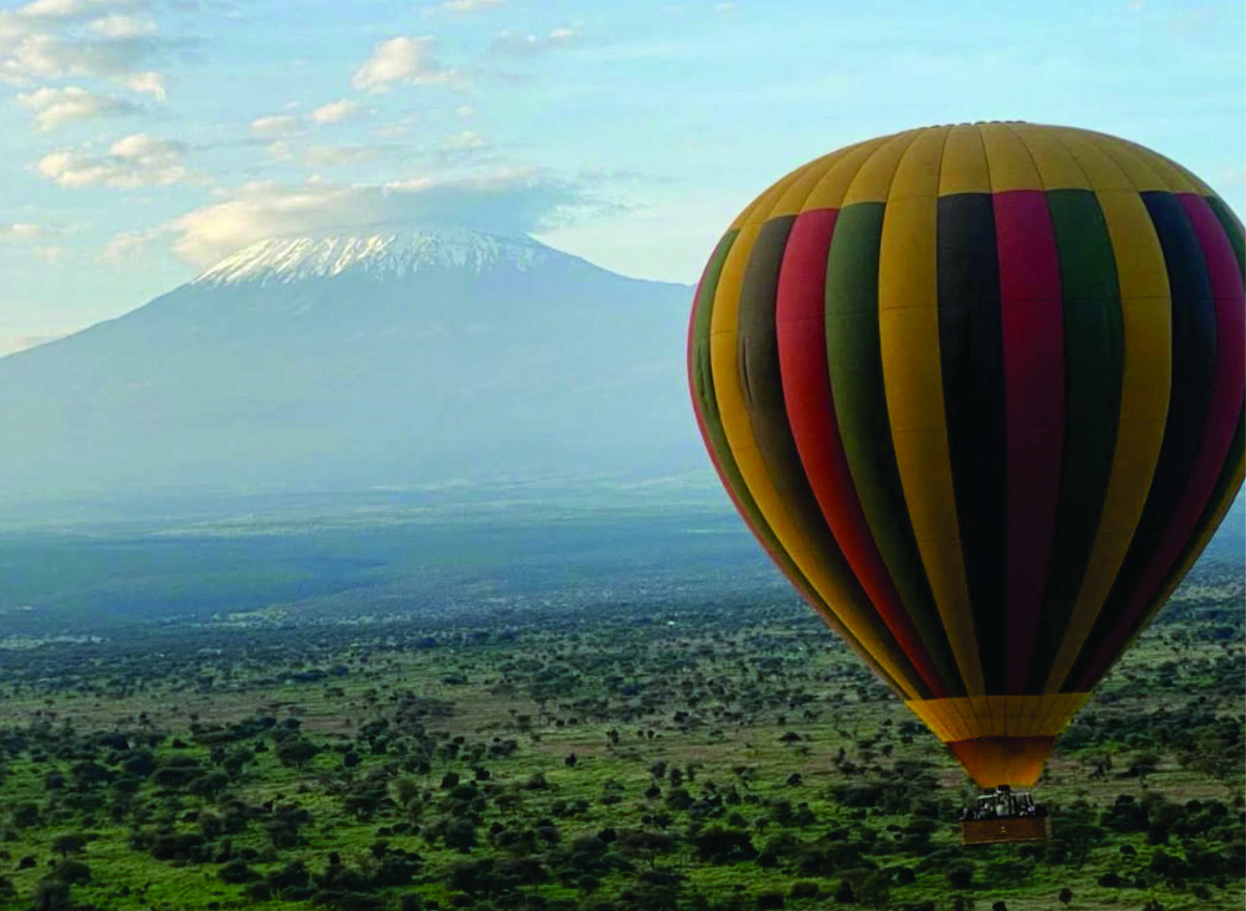 Guests climbing into a hot air balloon basket with crew assisting